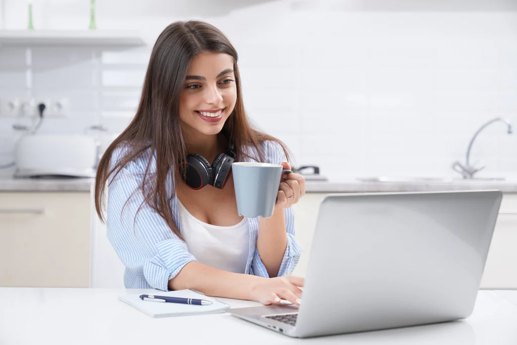 Joven mujer recibiendo formación de artistas en Madrid online con café en mano